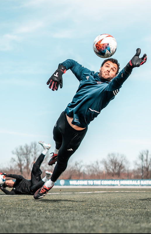 Torhüter beim Fangen eines Balls während dem Torwarttraining.